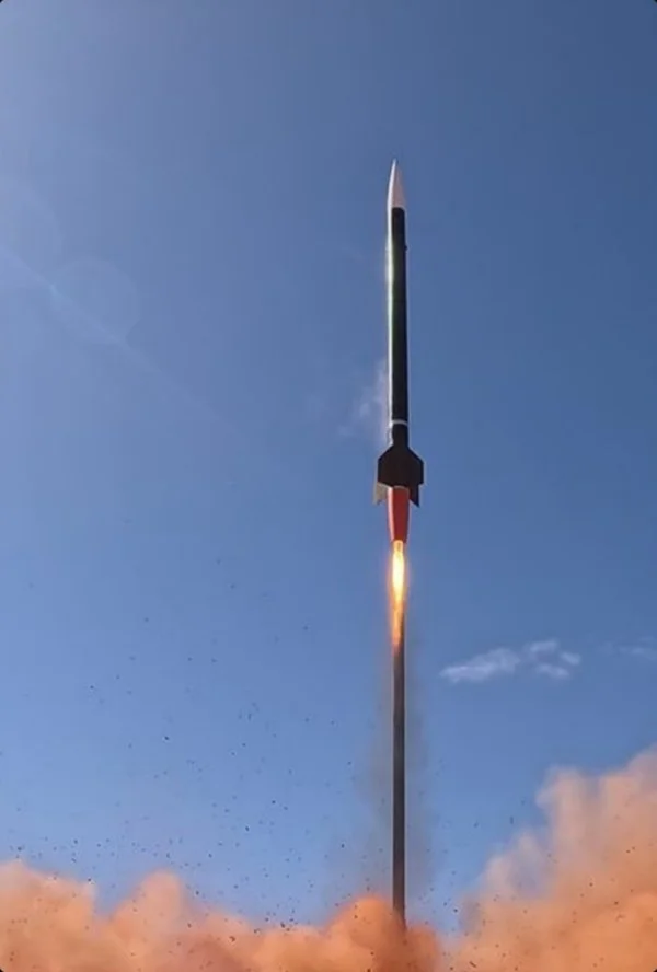 Sunburnt Space rocket lifting off under a blue sky