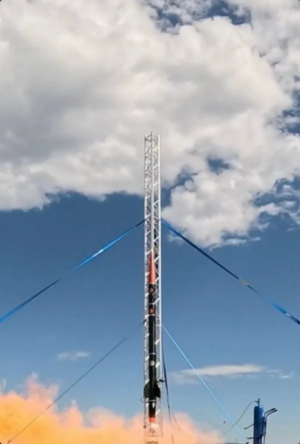 Rocket launching from its tower under a cloudy sky